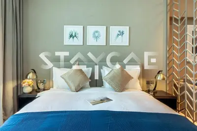 a bedroom with a large bed with three pictures on the wall at Staycae Holiday Homes - Prive in Dubai