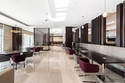 a restaurant with black tables and purple chairs at The Smart Concierge - Damac Maison Prive in Dubai