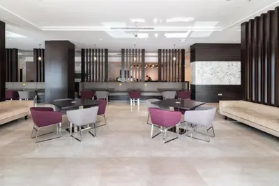 a lobby with tables and chairs and a bar at The Smart Concierge - Damac Maison Prive in Dubai