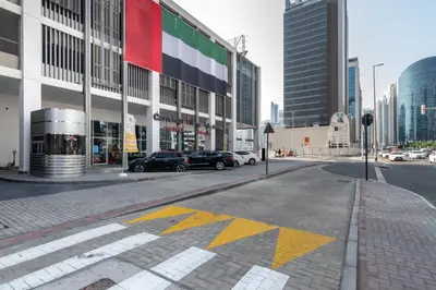 a street with cars parked in front of a building at The Smart Concierge - Damac Maison Prive in Dubai