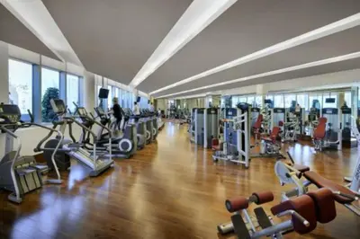 a gym with several treadmills and machines in a room at Fashion Avenue Dubai Mall Residences - Studio with balcony in Dubai