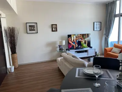 a living room with a couch and a tv at Luxury 1br in Dubai Marina, ask for July Full month offer in Dubai