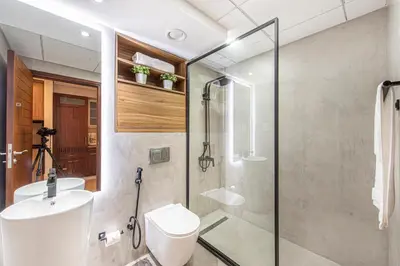 a bathroom with a shower and a toilet and a sink at Nasma Luxury Stays - Boulevard Central Tower in Dubai