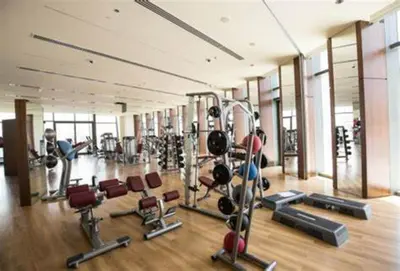 a gym with a lot of treadmills and machines at Nasma Luxury Stays - Boulevard Central Tower in Dubai