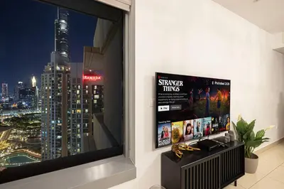 a large window with a view of a city at night at FIRST CLASS 3BR Burj Khalifa & Fountain View in Dubai