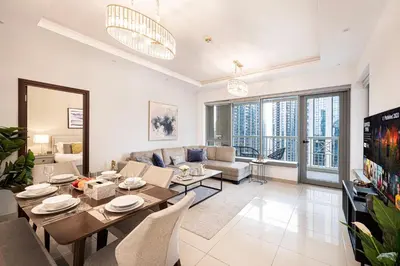 a living room with a dining table and a couch at FIRST CLASS 3BR Burj Khalifa & Fountain View in Dubai