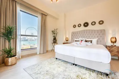 a bedroom with a large bed and a large window at Glamorous 1BR Apartment in Rimal 3 Jumeirah Beach Residence by Deluxe Holiday Homes in Dubai