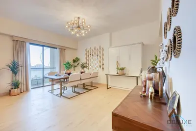 a dining room and living room with a table and chairs at Glamorous 1BR Apartment in Rimal 3 Jumeirah Beach Residence by Deluxe Holiday Homes in Dubai