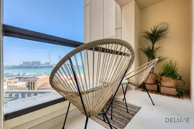 two chairs on a balcony with a view of the ocean at Glamorous 1BR Apartment in Rimal 3 Jumeirah Beach Residence by Deluxe Holiday Homes in Dubai