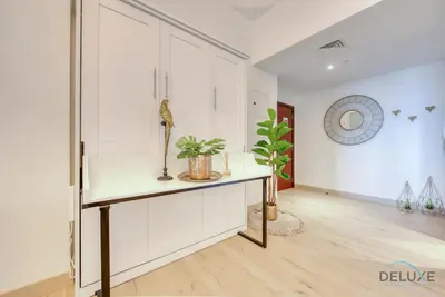 a room with white cabinets and a table with plants at Glamorous 1BR Apartment in Rimal 3 Jumeirah Beach Residence by Deluxe Holiday Homes in Dubai