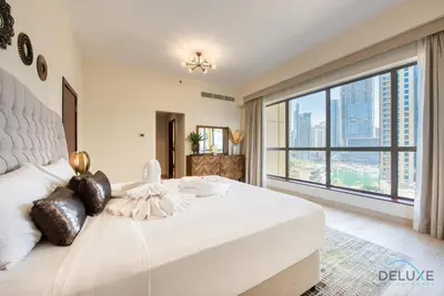 a bedroom with a large white bed with a large window at Glamorous 1BR Apartment in Rimal 3 Jumeirah Beach Residence by Deluxe Holiday Homes in Dubai
