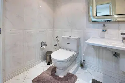 a white bathroom with a toilet and a sink at Stunning 2BD sea view apartment in Jbr in Dubai
