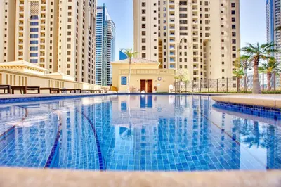 a swimming pool in a city with tall buildings at Stunning 2BD sea view apartment in Jbr in Dubai
