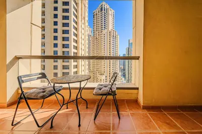 a balcony with a table and two chairs and a window at Brand new Rimal 2BD in front of The JBR Beach in Dubai