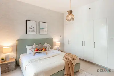 a bedroom with a large bed and two lamps at Blissful 1BR in Safi Town Square by Deluxe Holiday Homes in Dubai