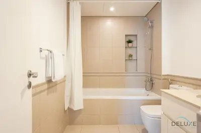 a bathroom with a tub and a toilet and a sink at Blissful 1BR in Safi Town Square by Deluxe Holiday Homes in Dubai