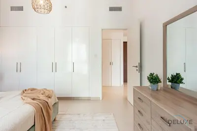 a bedroom with a bed and a dresser and a mirror at Blissful 1BR in Safi Town Square by Deluxe Holiday Homes in Dubai