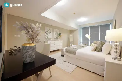 a bedroom with a bed and a table with a vase at HiGuests - Fabulous Duplex With Breathtaking Lake Views in Dubai