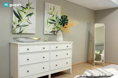 a bedroom with a white dresser and a mirror at HiGuests - Fabulous Duplex With Breathtaking Lake Views in Dubai