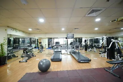 a gym with several treadmills and exercise machines at Al Waleed Holiday Homes in Dubai