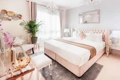 a white bedroom with a large bed and a chair at Elite Royal Apartment - Full Burj Khalifa & Fountain View - Sapphire in Dubai