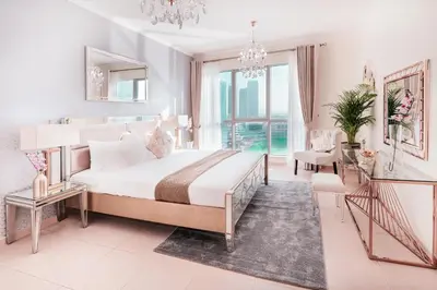a white bedroom with a large bed and a chandelier at Elite Royal Apartment - Full Burj Khalifa & Fountain View - Sapphire in Dubai