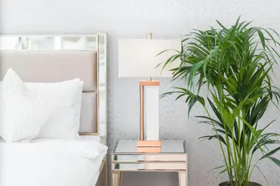 a bedroom with a bed and a lamp and a plant at Elite Royal Apartment - Full Burj Khalifa & Fountain View - Sapphire in Dubai