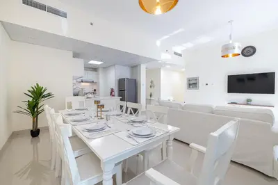 a white dining room with a white table and white chairs at Charming 3 BR with walking distance to the Beach in Dubai