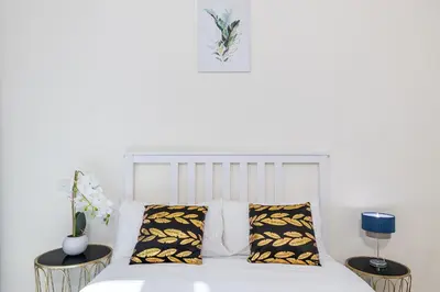 a bedroom with a white bed with two tables at Charming 3 BR with walking distance to the Beach in Dubai