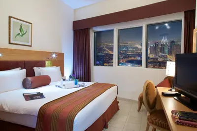 a hotel room with a bed and a desk with a television at Tamani Marina Hotel & Apartments in Dubai