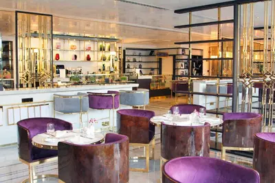 a restaurant with purple chairs and tables and a bar at Tamani Marina Hotel & Apartments in Dubai