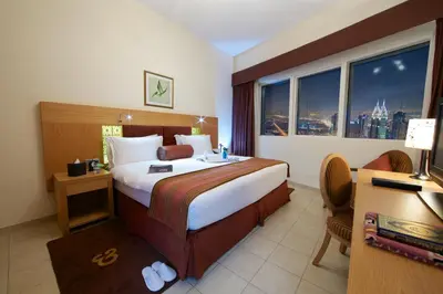 a hotel room with a bed and a desk and window at Tamani Marina Hotel & Apartments in Dubai