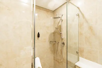 a bathroom with a shower with a glass door at Resivation Hotel in Dubai