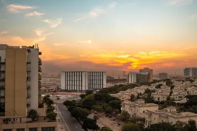 a city skyline with the sunset in the background at Resivation Hotel in Dubai