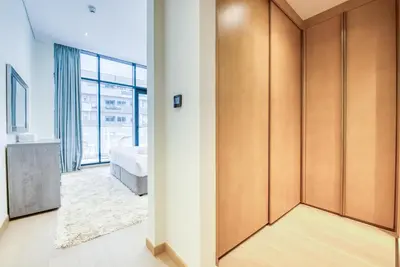 a bedroom with a bed and a large window at RH- Modern Comfort & bright 1BR near Dubai Mall, City Views in Dubai