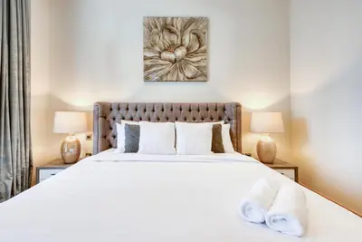 a bedroom with a large white bed with two lamps at RH- Downtown Oasis, Spacious 01 BR in Downtown near Dubai Mall in Dubai