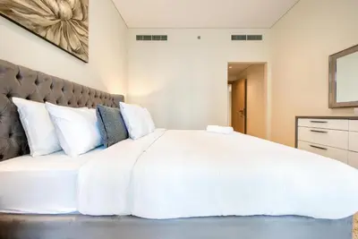 a bedroom with a large bed with white sheets and pillows at RH- Downtown Oasis, Spacious 01 BR in Downtown near Dubai Mall in Dubai