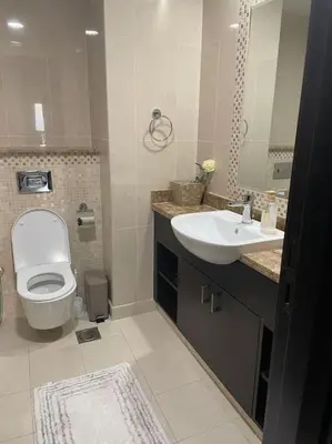 a bathroom with a white toilet and a sink at Balqis Residense Palm Jumeirah,Pool, Beach, Top floor, Full sea view, Restaurants in Dubai