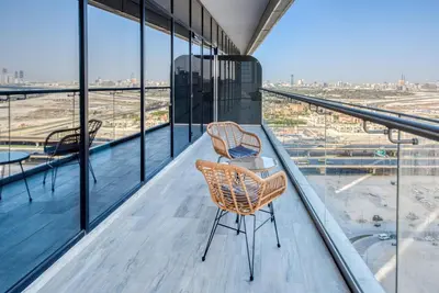 two chairs on a balcony with a view of an airport at RH- A Stylish Home Away from Home, Spacious 02 BR near Dubai Mall in Dubai
