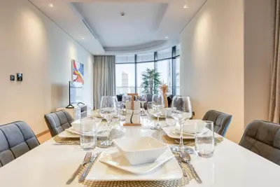 a dining room with a white table and chairs at RH- A Stylish Home Away from Home, Spacious 02 BR near Dubai Mall in Dubai