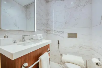 a white bathroom with a sink and a mirror at RH- A Stylish Home Away from Home, Spacious 02 BR near Dubai Mall in Dubai