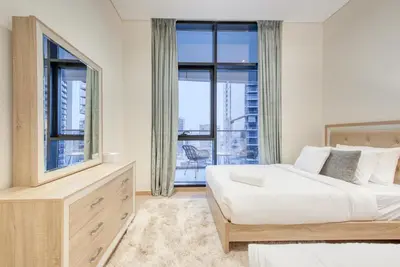 a bedroom with two beds and a large window at RH- Upscale Living in the Heart of the City, 02BR, Near Dubai Mall in Dubai
