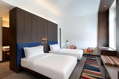 a hotel room with two beds and a desk at Aloft Al Mina, Dubai Jumeirah in Dubai