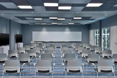 a conference room with white chairs and a projection screen at Aloft Al Mina, Dubai Jumeirah in Dubai