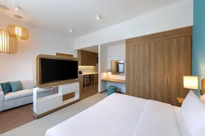 a bedroom with a bed and a tv and a couch at Element Al Mina, Dubai Jumeirah in Dubai