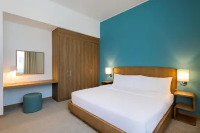 a bedroom with a white bed and a blue wall at Element Al Mina, Dubai Jumeirah in Dubai