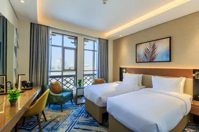 a hotel room with two beds and a balcony at S19 Hotel-Al Jaddaf Metro Station in Dubai