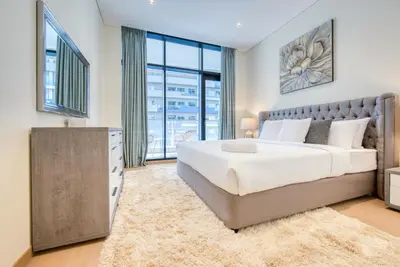 a bedroom with a large bed and a large window at RH- Downtown Delight, Chic 01BR near Dubai Mall & Burj Khalifa, RP Heights in Dubai