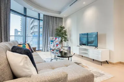 a living room with a couch and a tv at RH- Downtown Delight, Chic 01BR near Dubai Mall & Burj Khalifa, RP Heights in Dubai