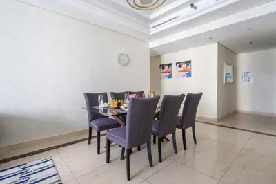 a dining room with a table with purple chairs at Frank Porter - Mon Reve in Dubai